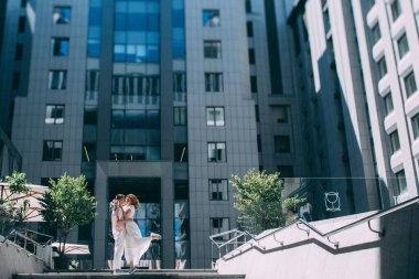 Güzel, mutlu gelin ve damat şehirde sarılıyor.      