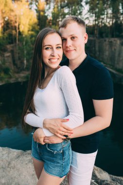 Nehir ve ormanın arka planında birbirini seven güzel genç bir çift. 