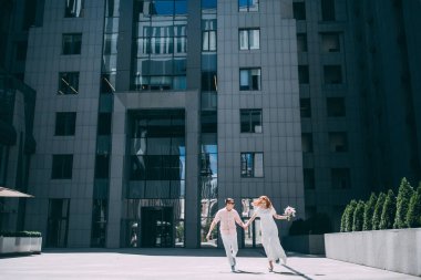 Mutlu genç gelin ve damat şehirde eğleniyor ve yürüyor.                    