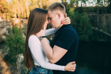 Nehir ve ormanın arka planında birbirini seven güzel genç bir çift. 