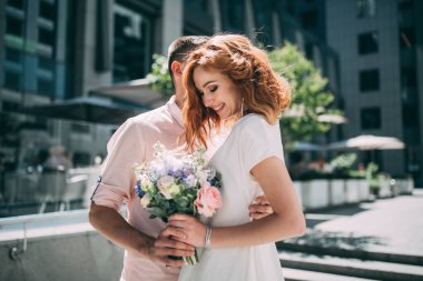 Mutlu gelin ve damat bir şehirde sarılıyor.