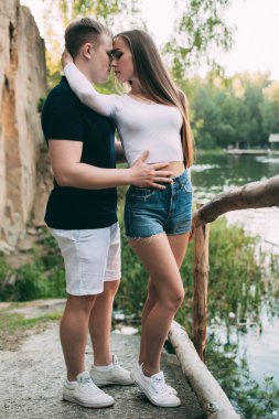 Güzel, genç ve sevgi dolu bir çift nehir kenarında kucaklaşıyor..       