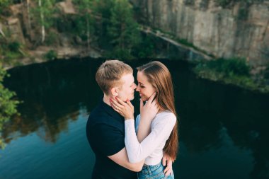 Nehir ve ormanın arka planında birbirini seven güzel genç bir çift. 