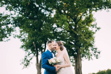 Güzel, mutlu, birbirine aşık bir çift dışarıda poz veriyor.                        