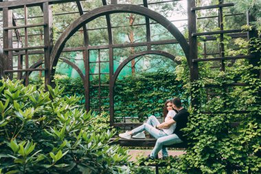 Genç, güzel, mutlu çift parkta birbirine sarılıyor.                