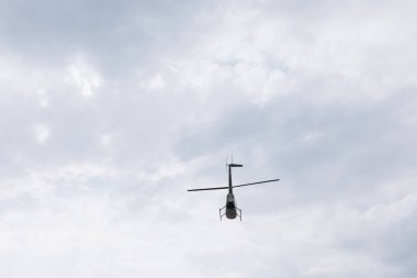 Bulutlu gökyüzünde uçan helikopterin alçak açılı görüntüsü