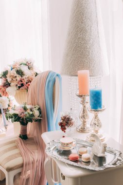 Lüks koltuğu, düğün buketleri ve mumları olan zarif bir iç mekan.               