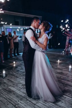 Genç ve güzel gelin ve damat gece dans edip öpüşüyor. 