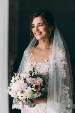 Bir buket çiçekli, mutlu gelinlik içindeki çekici gelin.