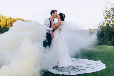Yeni evli çiftimiz düğün günü duman içinde poz veriyor.           