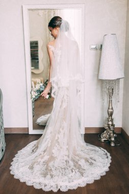 Gelinlik içinde zarif bir poz veren güzel bir gelin.  