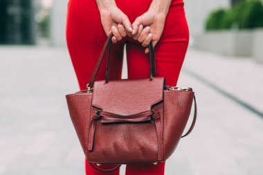 Kırmızı pantolonlu, deri çantalı bir kadın. 