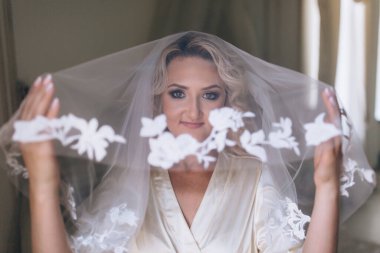 Lüks bir iç mekanda poz veren güzel genç bir gelinin portresi. Gelinin özel sabahı..                                   