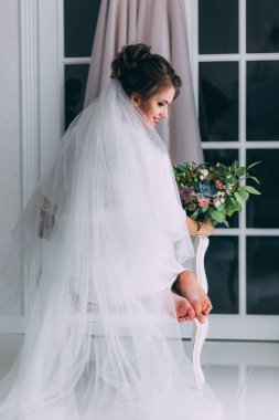 Duvağı ve düğün buketi olan güzel gelinin arka manzarası 