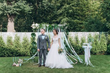 Güzel, mutlu gelin ve damat açık havada düğün töreninde.         