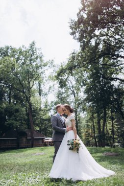 Parkta birlikte poz veren mutlu, genç, güzel bir çift.