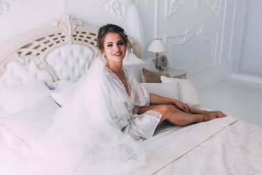 Yatakta poz veren güzel genç bir kadın, gelinin sabahı....       