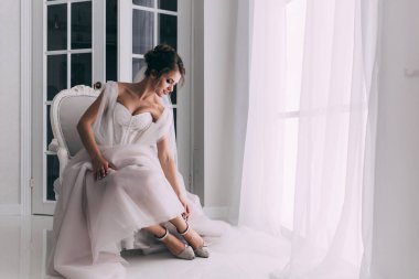 Gelinlik içinde zarif bir poz veren güzel bir gelin.  