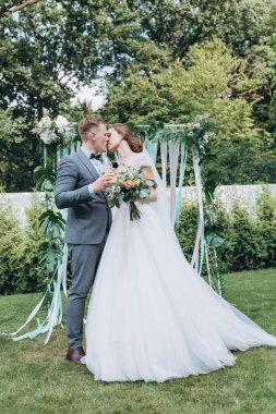 Güzel, mutlu gelin ve damat açık havada düğün töreninde.         