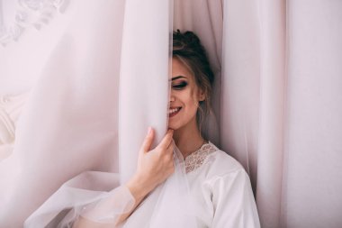 Mutlu genç gelin stüdyoda gelinlikle poz veriyor.