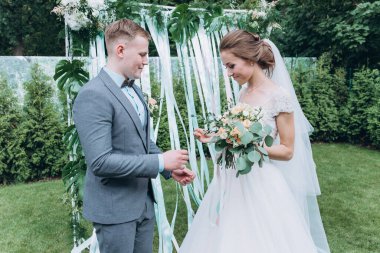 Damat ve güzel kemerli mutlu genç gelin açık hava düğün töreninde    