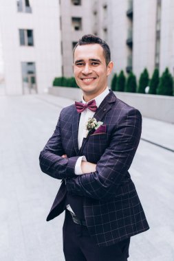 Takım elbiseli ve papyonlu yakışıklı damadın portresi.                 