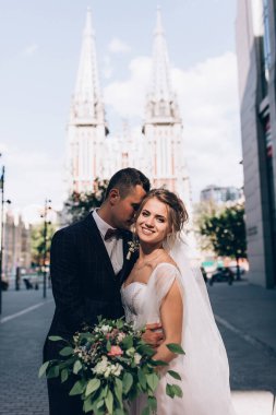 Güzel mutlu gelin ve damat düğün gününde şehirde poz veriyor.    