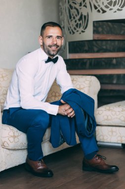 Takım elbiseli ve papyonlu yakışıklı damadın portresi.                 