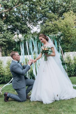 Damat ve güzel kemerli mutlu genç gelin açık hava düğün töreninde    