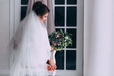 Duvağı ve düğün buketi olan güzel gelinin arka manzarası 