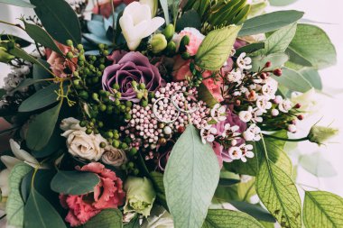 Yüzüklerin yakın görüntüsü ve güzel çiçekli düğün buketi.            