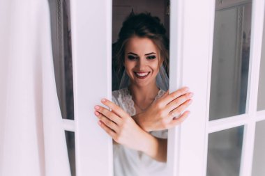 Mutlu genç gelin evlenmeye ve evde poz vermeye hazırlanıyor.             