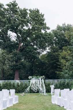 Açık hava düğün töreni için çiçeklerle süslenmiş güzel bir düğün kemeri.                  