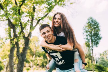 Genç güzel mutlu çift güneşli bir günde yaz parkında eğleniyor.. 