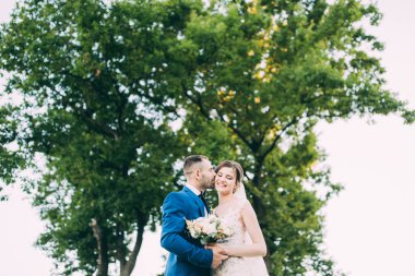 Güzel, mutlu, birbirine aşık bir çift dışarıda poz veriyor.                        