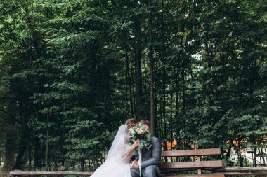 Gelin ve damat parkta bankta oturuyor.