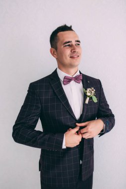 Takım elbiseli ve papyonlu yakışıklı damadın portresi.                 