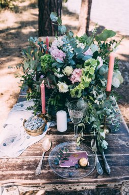 Çiçekli, mumlu ve yabanmersinli düğün masası.    