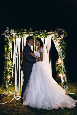 Mutlu genç gelin ve damat gece açık havada nikah töreninde