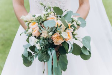 Gelin güzel bir buket tutuyor, yakın plan.       