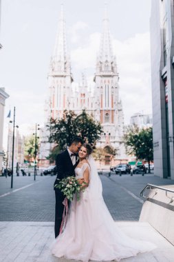 Güzel bir çift gelin ve damat şehirde poz veriyor.        