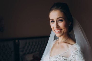 Peçeli güzel gelinin portresi kameraya gülümsüyor.