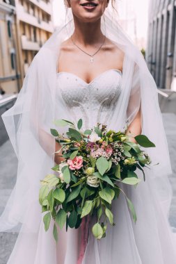 Gelin güzel bir buket tutuyor, yakın plan.       