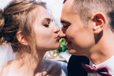 Mutlu gelinin güneşli bir günde damadı öptüğü yakın plan görüntüsü