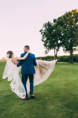 Mutlu gelin ve damat parkta düğün yürüyüşünde         