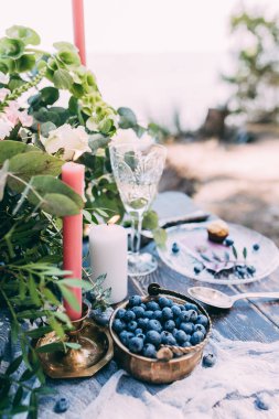 Çiçekli, mumlu ve yabanmersinli düğün masası.    