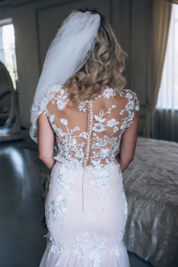 Beyaz elbiseli gelinin lüks içinde poz verişi.