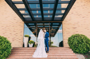 Genç ve mutlu bir çift düğün günü dışarıda poz veriyor.