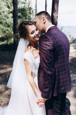 Güzel bir ormanın arka planında mutlu genç gelin ve damat