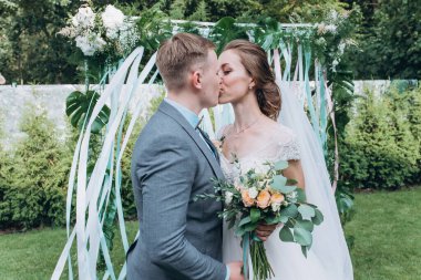 Damat ve güzel kemerli mutlu genç gelin açık hava düğün töreninde    